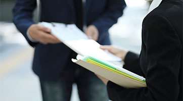 an image of 2 people looking at files