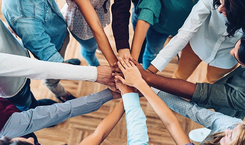 a group of people gathering all their hands together 